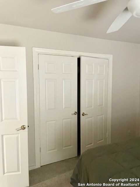 unfurnished bedroom featuring carpet flooring, ceiling fan, and a closet