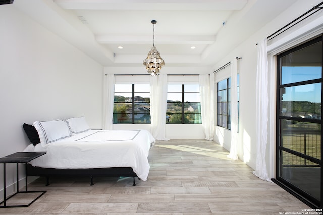 bedroom with an inviting chandelier, light wood-type flooring, and beam ceiling