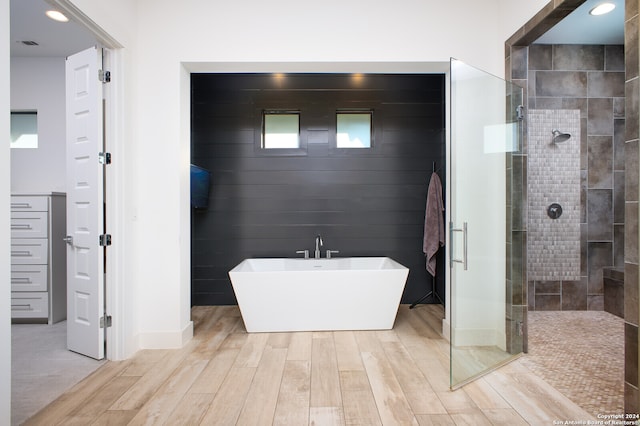 bathroom featuring independent shower and bath and hardwood / wood-style floors