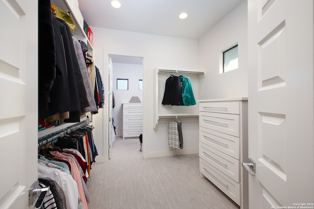 walk in closet featuring light carpet