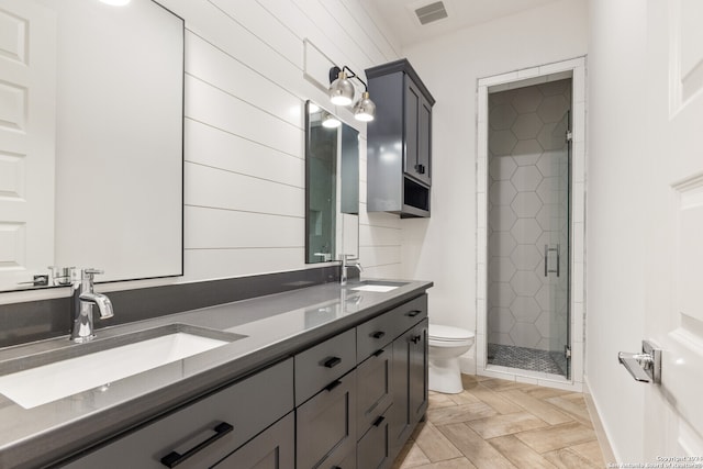 bathroom with vanity, toilet, and a shower with door