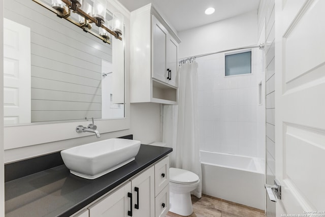 full bathroom with shower / bath combo, hardwood / wood-style flooring, vanity, and toilet