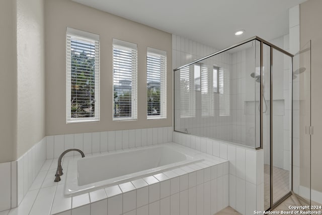 bathroom with a healthy amount of sunlight and separate shower and tub