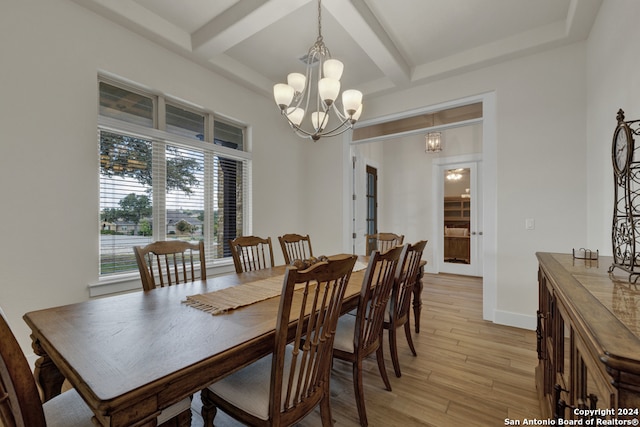 dining space featuring light wood-type flooring, beamed ceiling, and a notable chandelier