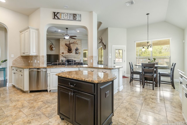 kitchen featuring light stone counters, a brick fireplace, backsplash, kitchen peninsula, and dishwasher