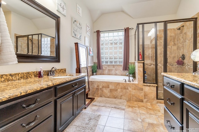 bathroom with plus walk in shower, vaulted ceiling, tile patterned flooring, and vanity