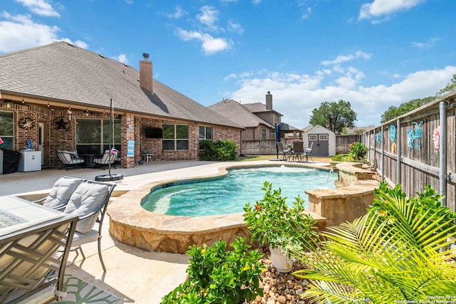 view of pool featuring a patio, a jacuzzi, and a storage unit