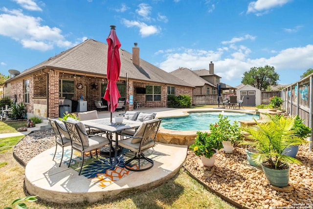 view of pool featuring a storage shed and a patio area