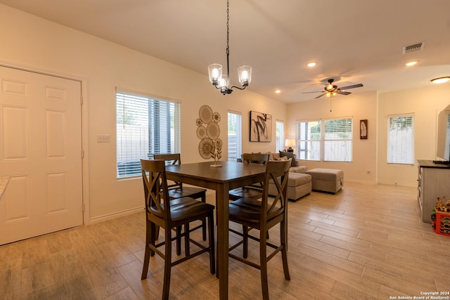 dining space featuring ceiling fan with notable chandelier, light hardwood / wood-style floors, and a healthy amount of sunlight