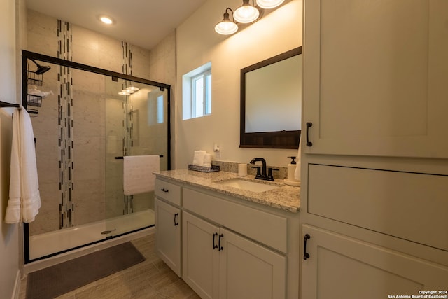 bathroom with an enclosed shower and vanity