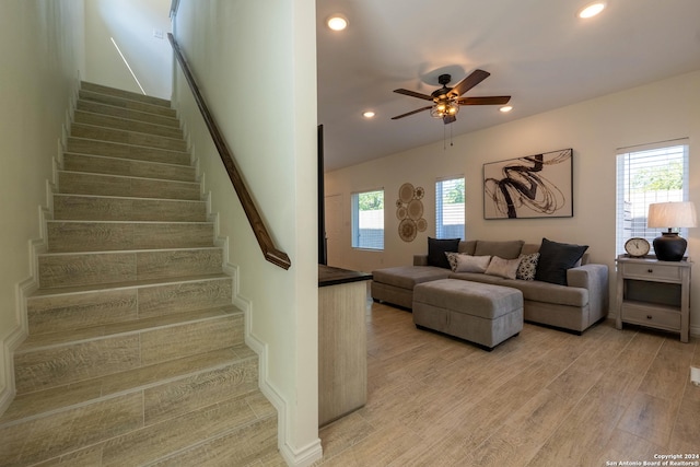 living room featuring ceiling fan, light wood-type flooring, and a wealth of natural light