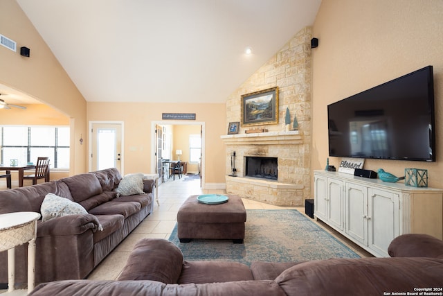 living room featuring a fireplace, high vaulted ceiling, light tile patterned floors, and ceiling fan