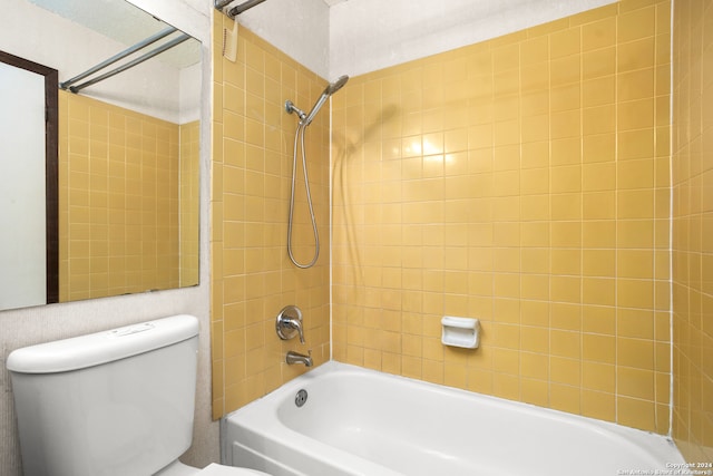 bathroom featuring tiled shower / bath combo and toilet