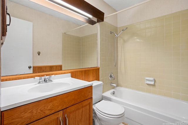 full bathroom featuring tiled shower / bath, vanity, and toilet