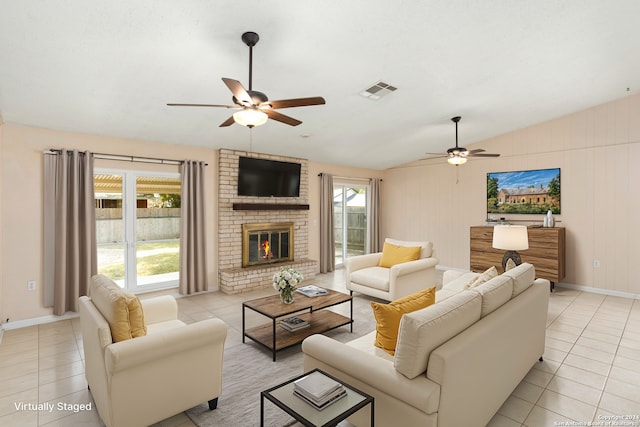 tiled living room with a brick fireplace, lofted ceiling, ceiling fan, and a healthy amount of sunlight