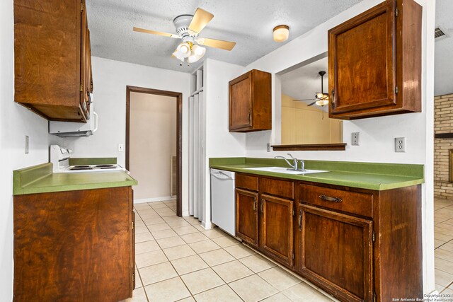 kitchen with white appliances, a textured ceiling, light tile patterned floors, and sink