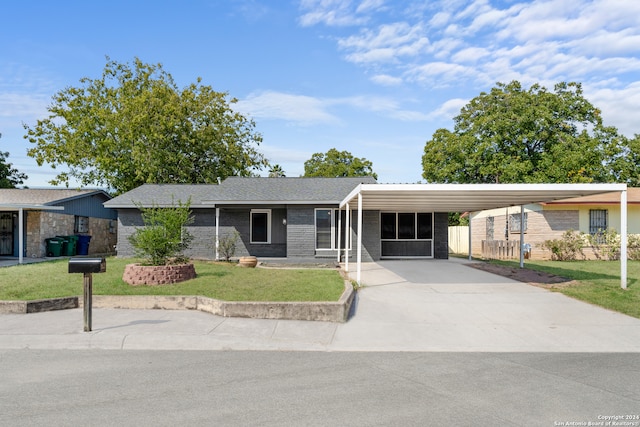 single story home with a front lawn and a carport