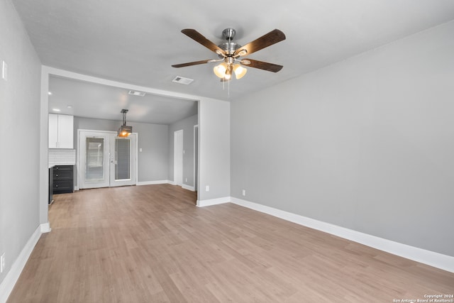 unfurnished living room with light hardwood / wood-style flooring, ceiling fan, and french doors