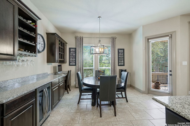 dining space featuring a notable chandelier, beverage cooler, and light tile patterned floors