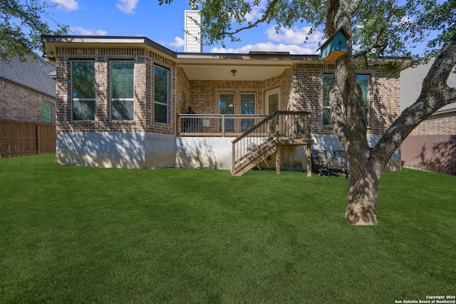 back of property with a yard and covered porch