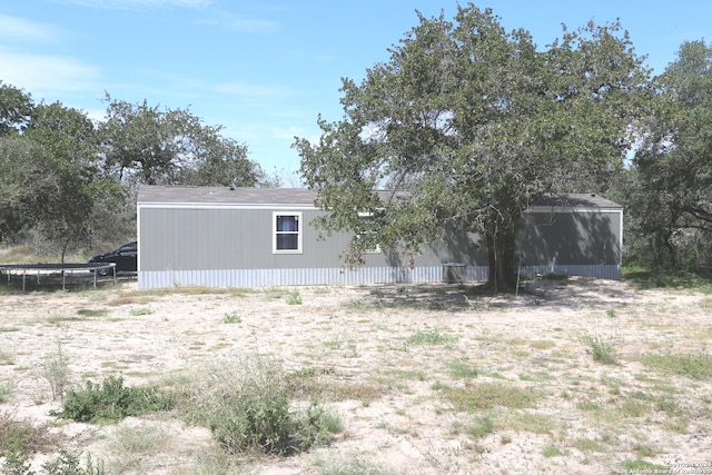 back of house with a trampoline