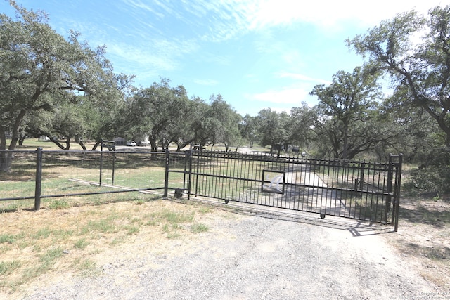 view of gate featuring a rural view and a lawn