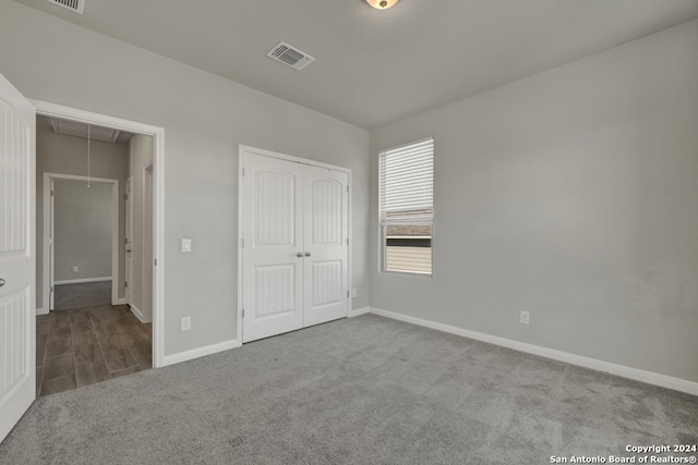 unfurnished bedroom featuring light carpet and a closet