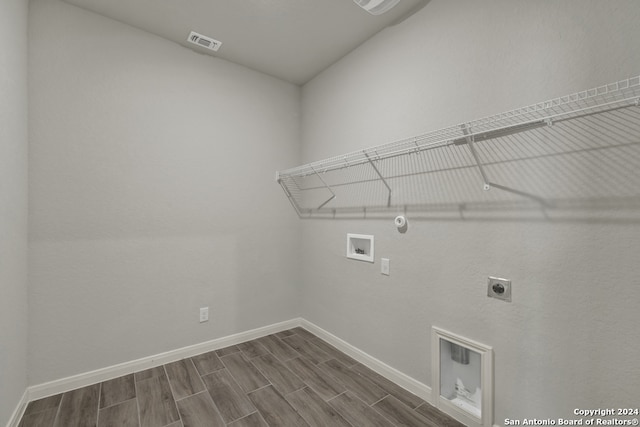 laundry area with washer hookup, hookup for an electric dryer, hookup for a gas dryer, and dark hardwood / wood-style flooring