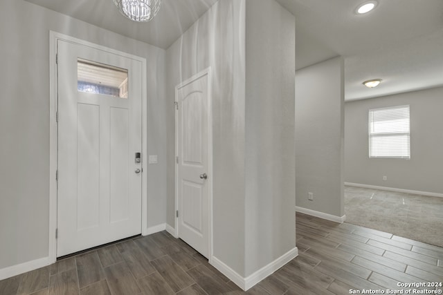 foyer with wood-type flooring and a notable chandelier