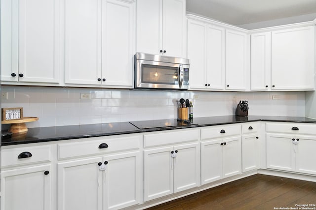 kitchen with dark hardwood / wood-style flooring, decorative backsplash, white cabinetry, and black electric cooktop