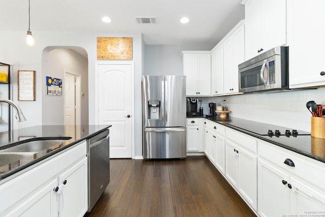 kitchen with sink, white cabinetry, hanging light fixtures, appliances with stainless steel finishes, and dark hardwood / wood-style flooring