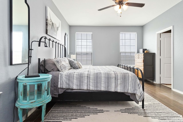 bedroom featuring multiple windows, hardwood / wood-style flooring, and ceiling fan