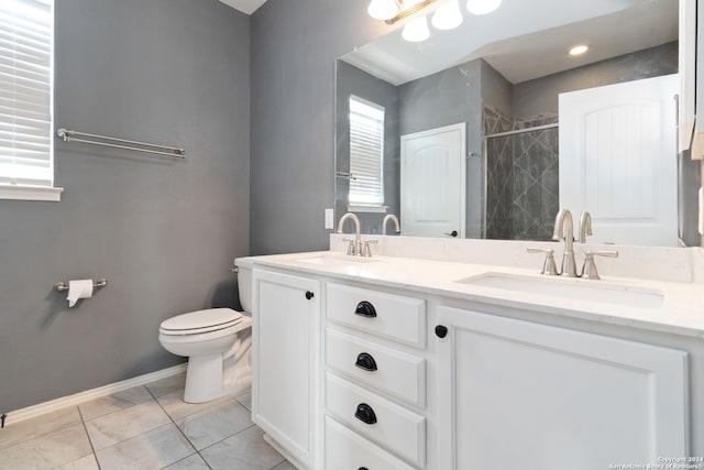 bathroom featuring vanity, toilet, and tiled shower