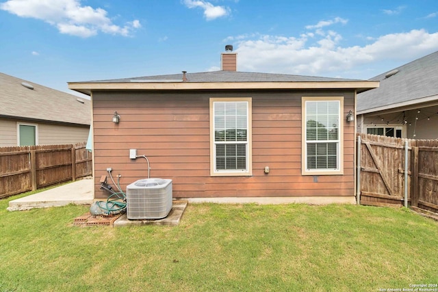 back of house with cooling unit, a patio, and a yard