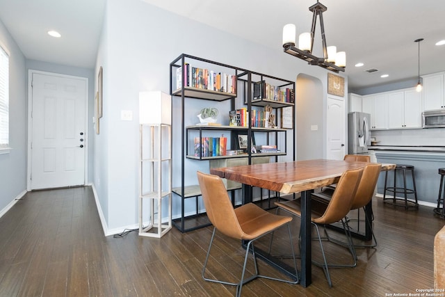 dining space with an inviting chandelier and dark hardwood / wood-style floors