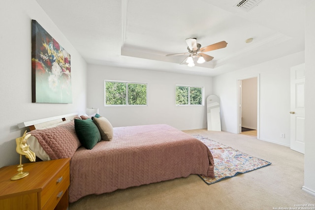 bedroom featuring light colored carpet, ceiling fan, and a raised ceiling