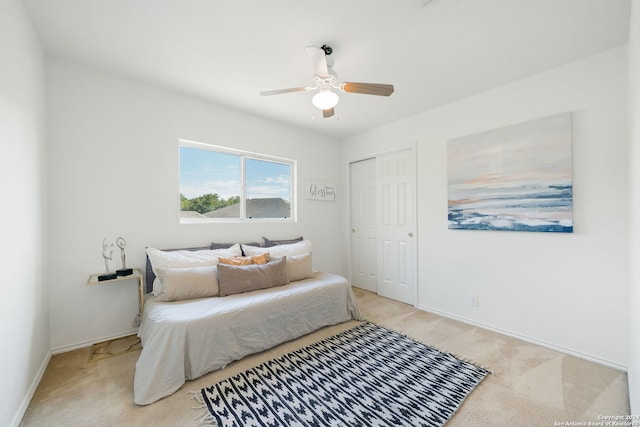 carpeted bedroom featuring ceiling fan and a closet