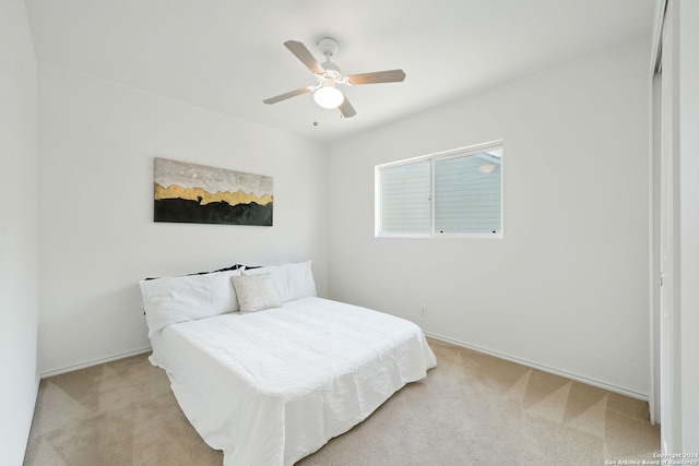 bedroom with ceiling fan and light carpet