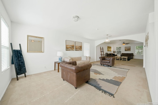 carpeted living room with ceiling fan