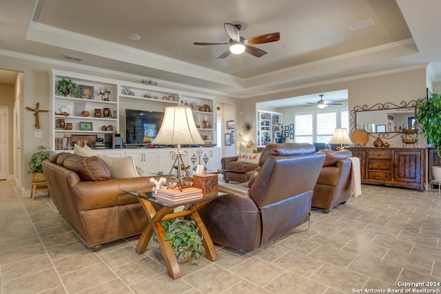 living room with ornamental molding, a tray ceiling, and ceiling fan