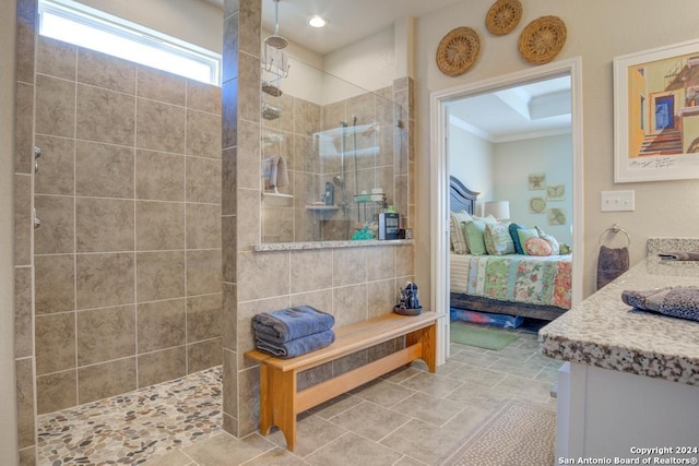 bathroom featuring a tile shower, ornamental molding, tile patterned floors, and vanity