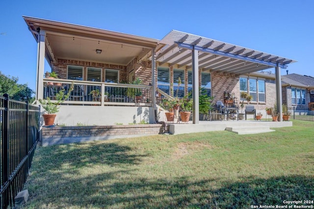 rear view of property with a patio, a pergola, and a yard