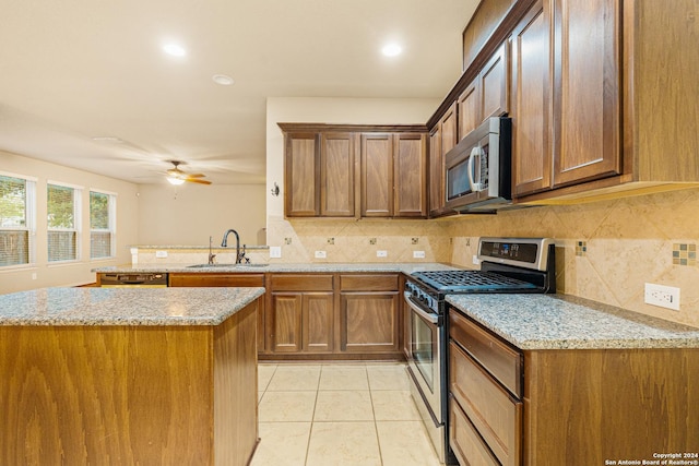 11806 Jasmine Way, San Antonio, TX 78253 - kitchen with backsplash, appliances with stainless steel finishes, a sink, light tile patterned floors, and a peninsula