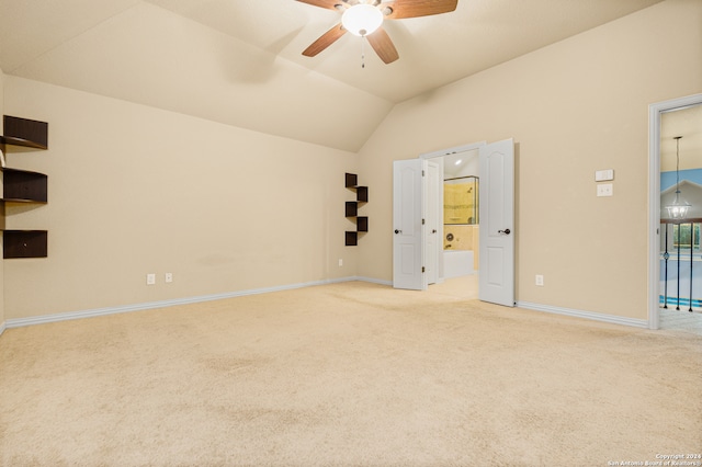 carpeted spare room featuring lofted ceiling and ceiling fan