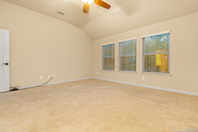 spare room with carpet, vaulted ceiling, and ceiling fan