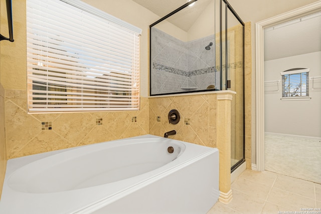 bathroom featuring a textured ceiling, shower with separate bathtub, vaulted ceiling, and tile patterned floors