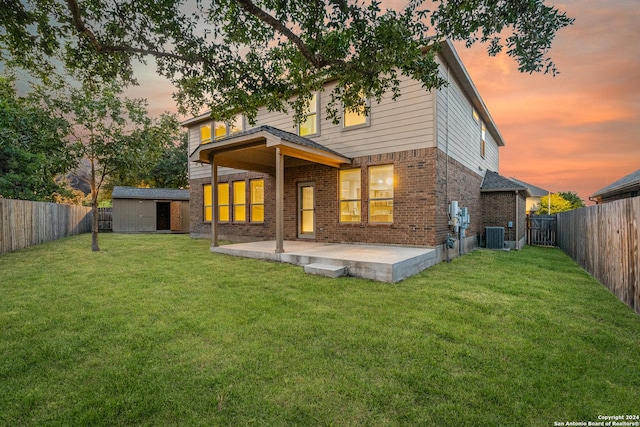 11806 Jasmine Way, San Antonio, TX 78253 - back of house at dusk with a fenced backyard, a patio, a yard, and brick siding