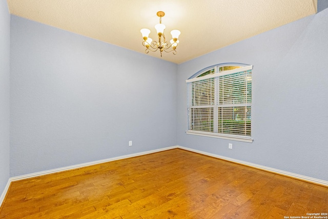 11806 Jasmine Way, San Antonio, TX 78253 - spare room with an inviting chandelier, baseboards, and wood finished floors