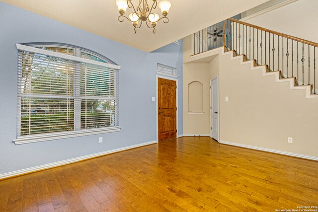 unfurnished room featuring hardwood / wood-style flooring and a chandelier