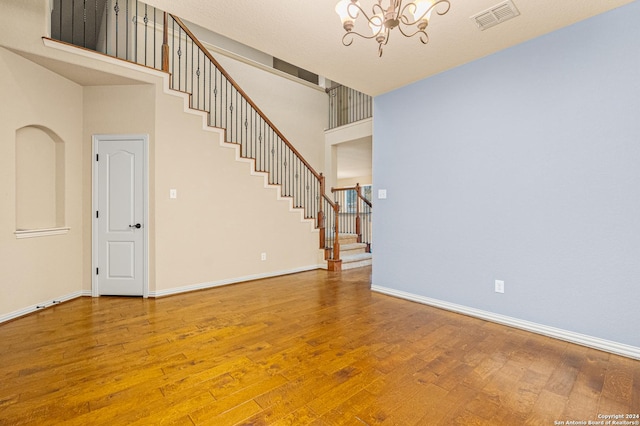 11806 Jasmine Way, San Antonio, TX 78253 - unfurnished living room featuring an inviting chandelier, stairs, baseboards, wood finished floors, and visible vents